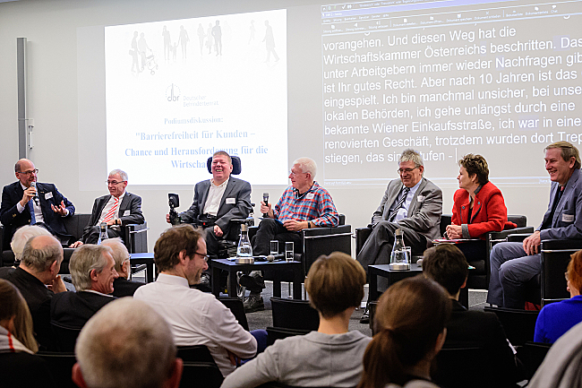 Die Teilnehmerinnen und Teilnehmer der Podiumsdiskussion sitzen vorne und diskutieren